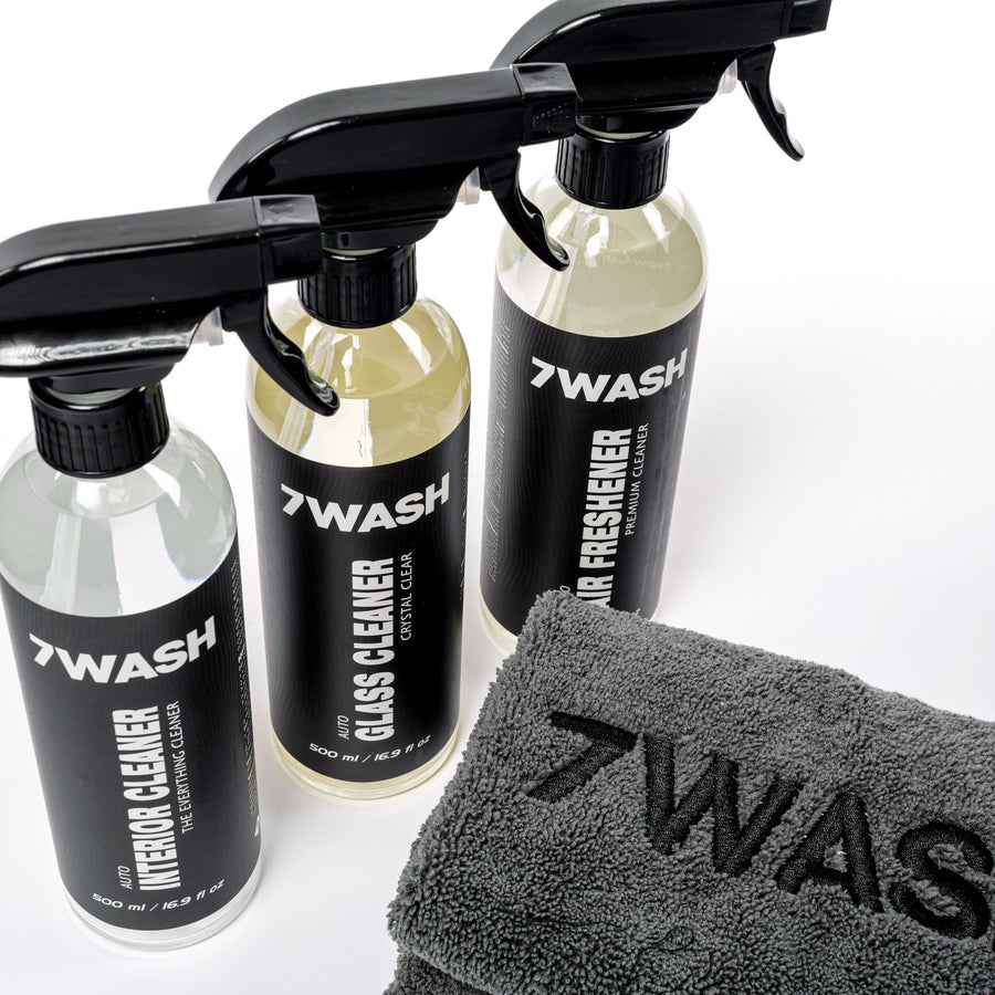 Three 7WASH interior spray bottles next to a 7WASH microfiber towel