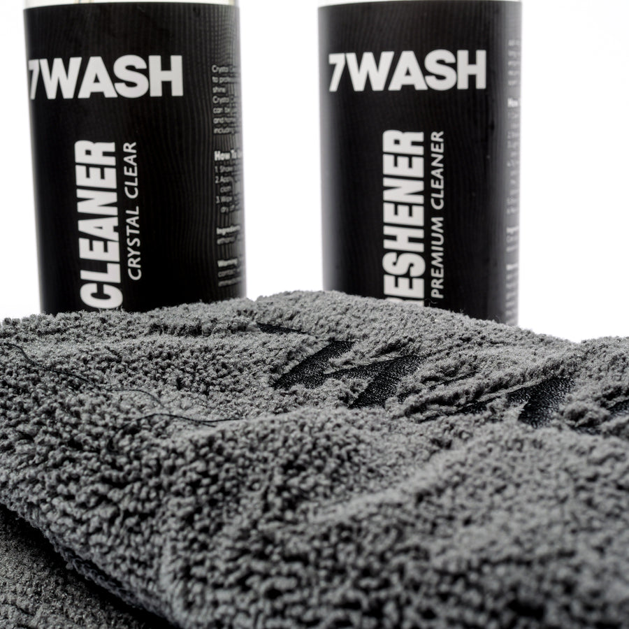 Close-up: 7WASH cleaner and freshener bottles on a microfiber towel